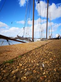 Sailboats moored on sea shore against sky