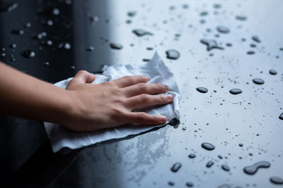 High angle view of woman hand on wet glass