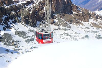 Ski lift on snowcapped mountains against sky