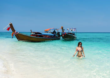 Young woman in boat on sea against sky