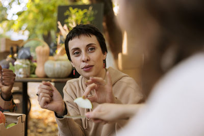 Portrait of smiling young woman drinking glass