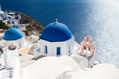 High angle view of building by sea against blue sky