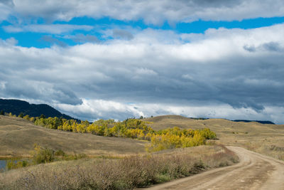 Road amidst field against sky