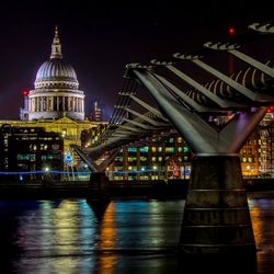 Illuminated cathedral by river at night