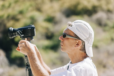 Side view of man using video camera