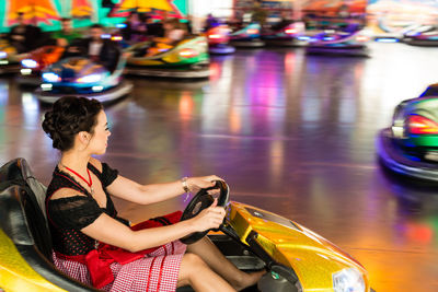 Woman enjoying in bumper car at amusement park