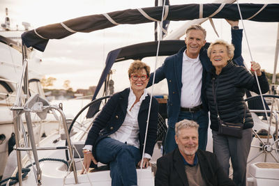 Portrait of smiling male and female senior friends in yacht during vacation