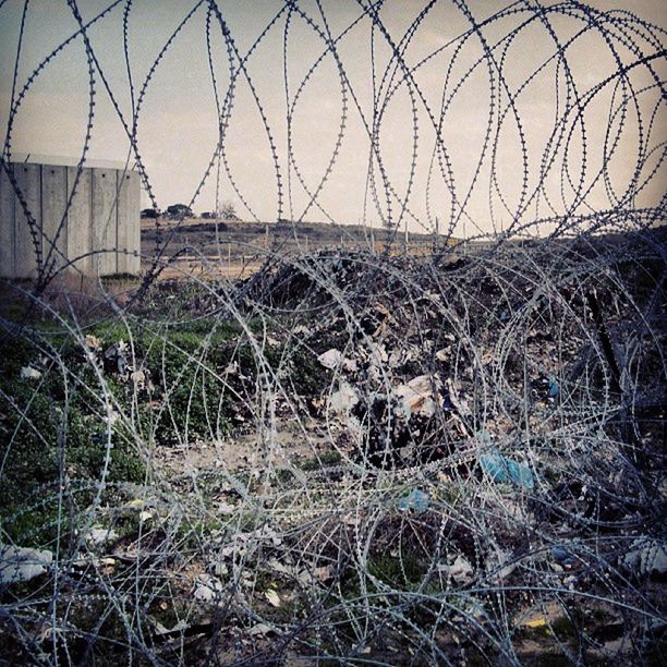 built structure, architecture, plant, building exterior, abandoned, metal, chainlink fence, fence, damaged, protection, grass, safety, sky, day, field, no people, obsolete, security, outdoors, broken