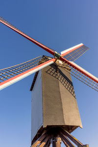 Low angle view of traditional windmill against clear blue sky