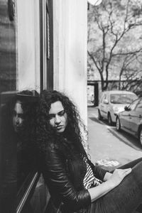 Portrait of woman sitting by window