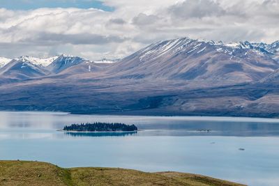 Scenic view of lake by mountain against sky