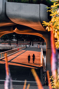 People walking in morning sunlight on waterfront 