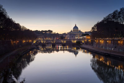 The bridge of sant'angelo, the tiber river and in the basilica of san pietro, at the sunset