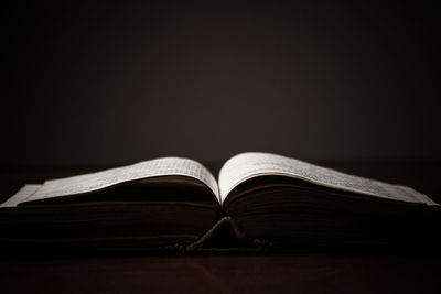 Close-up of book on table against black background