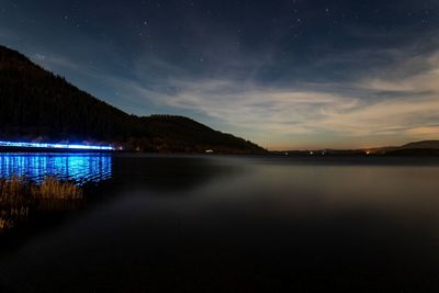 Scenic view of lake against sky at night