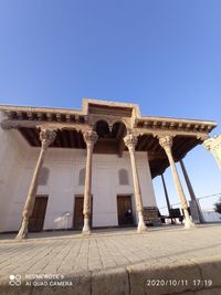 Low angle view of historical building against clear blue sky