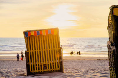 Lifeguard hut on beach against sky during sunset