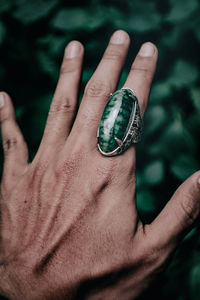 Cropped hand of person holding crystal ball ring