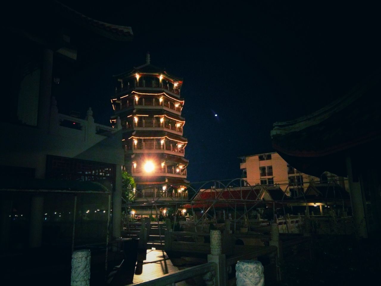 LOW ANGLE VIEW OF ILLUMINATED BUILDINGS AT NIGHT