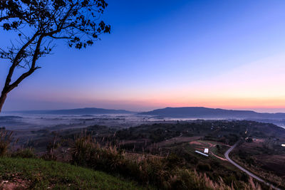 Scenic view of landscape against clear sky at sunset