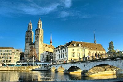 Bridge over river in city against sky