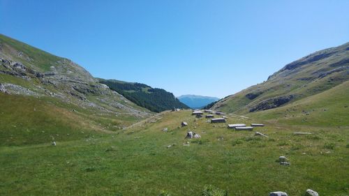 Scenic view of landscape and mountains against clear blue sky