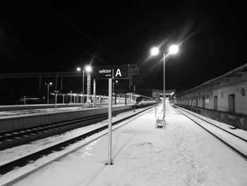 Illuminated railroad station platform during winter at night