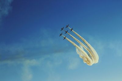 Low angle view of airplane flying against blue sky