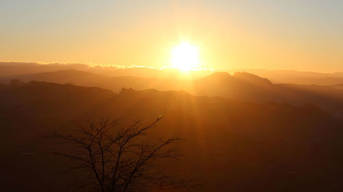 Scenic view of silhouette mountains against sky during sunset