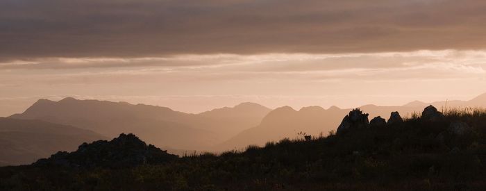 Scenic view of silhouette mountains against sky at sunset