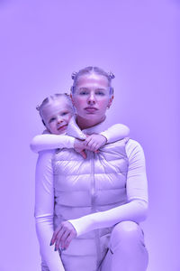 Portrait of young woman holding gift against blue background