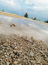 Surface level of stones on beach against sky