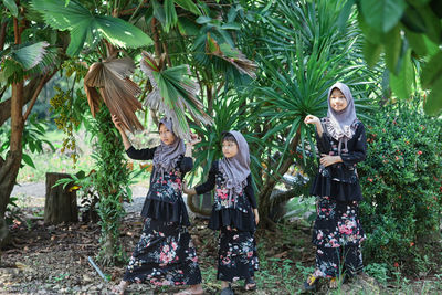 Cute asian muslim girls wearing hijab fashion with green tree in rural scene