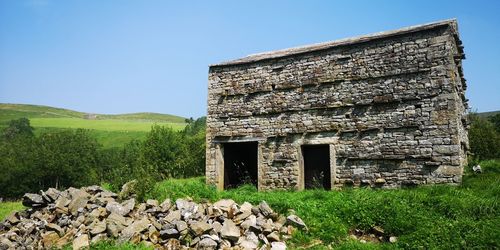 Old ruin on field against clear sky