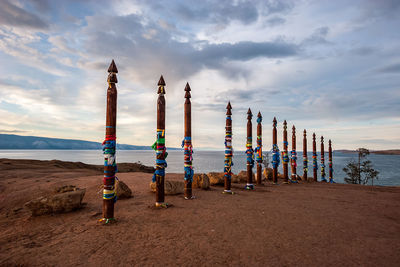 Wooden posts on beach against sky