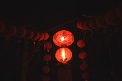 Low angle view of illuminated lanterns hanging at night