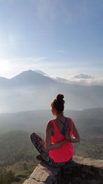 Woman doing yoga against mountains