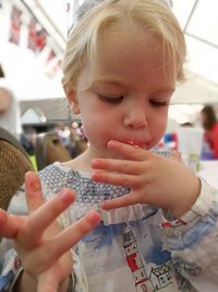 Close-up of girl licking finger