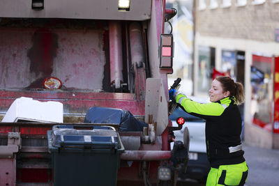 Woman operating garbage truck