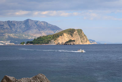 Scenic view of sea and mountains against sky