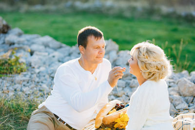 Rear view of couple sitting on land