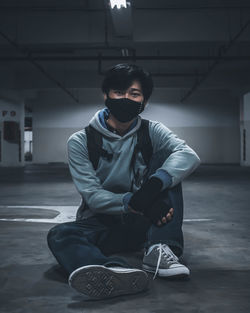 Portrait of young man standing against wall