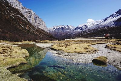 Scenic view of snowcapped mountains against blue sky