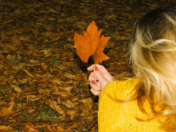 Close-up of woman holding autumn leaves