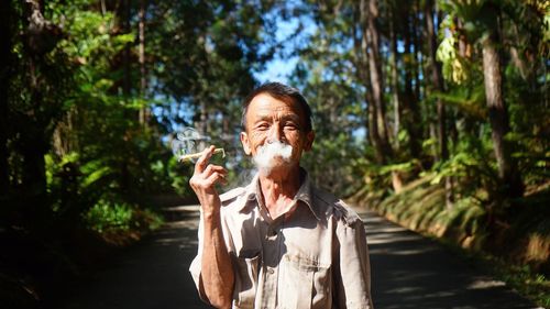 Portrait of man standing against trees