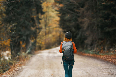 Rear view of man walking on road