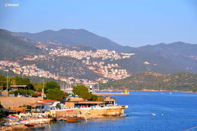 Scenic view of townscape by sea against sky