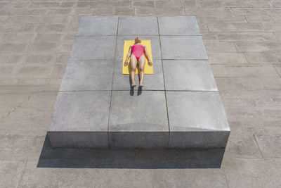 Woman sunbathing while lying on towel