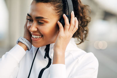 Smiling woman looking away while listening music