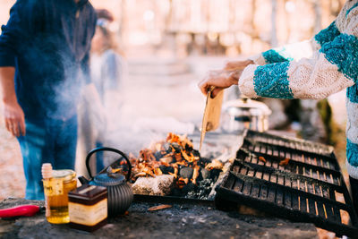 Cropped hands of woman vendor preparing food at market stall